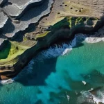 지구과학과 플라스틱 오염 - **Prompt:** A close-up, highly detailed shot of a "plastiglomerate" rock formation on a rugged, sun-...